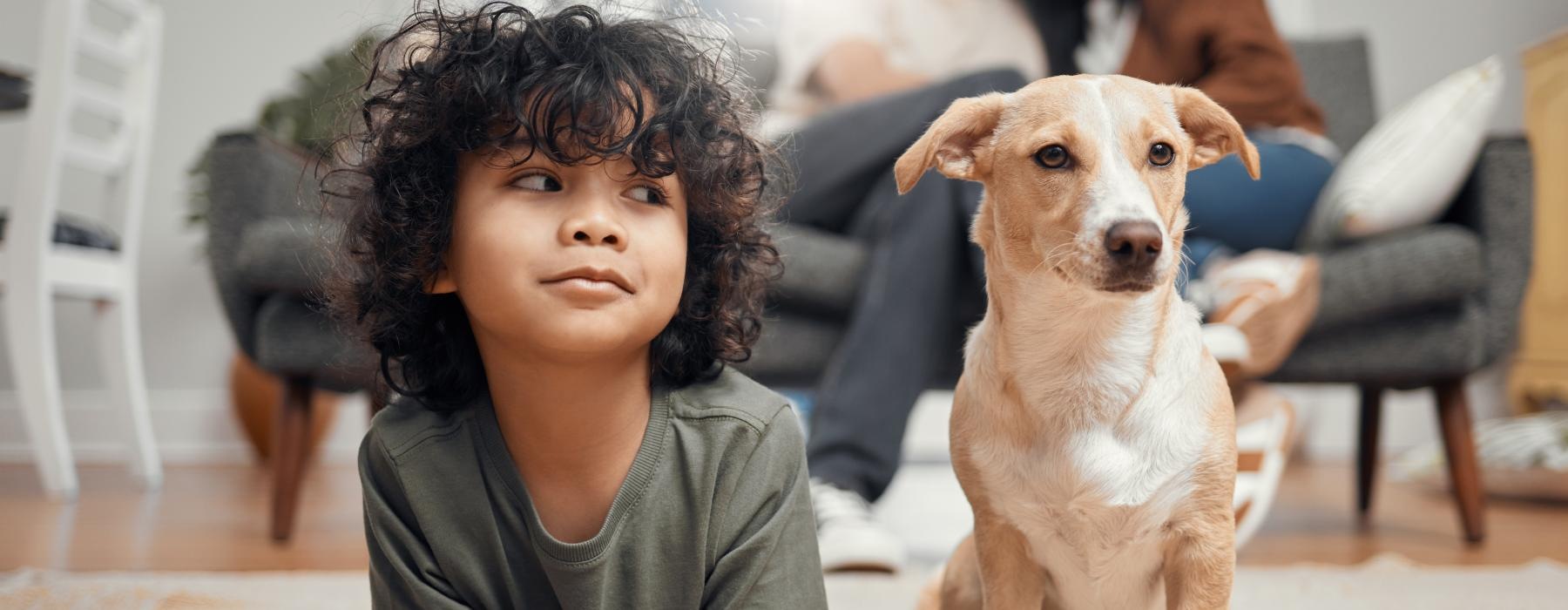 a child and a dog lay on the floor next to each other