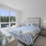 Furnished bedroom with coastal inspired decor, a bed, two end tables, and oversized window