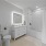 Large bathroom with backlit vanity mirror, large tub, and white tile