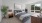 Spacious bedroom with bed, two side tables, plant, mirror, and oversized windows with natural light
