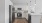 Kitchen with quartz island, white backsplash, stainless steel appliances, and white cabinetry