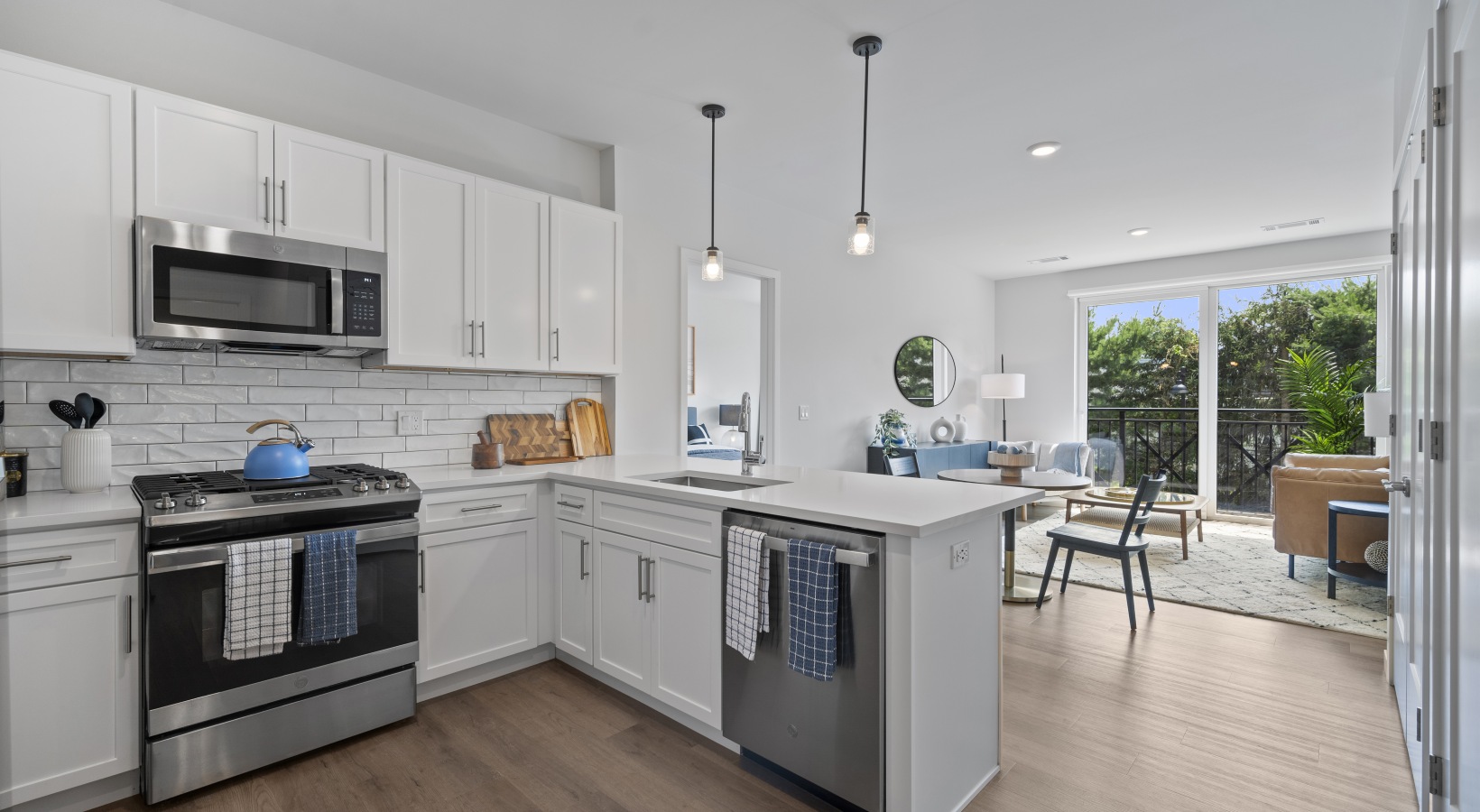 Beautiful kitchens with designer finishes Model kitchen at Riverside Wilton Apartments in Wilton, CT, featuring wood grain flooring and white cabinetry.
