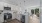 View of kitchen island, white cabinetry,  and peek of living room and separate dining area.