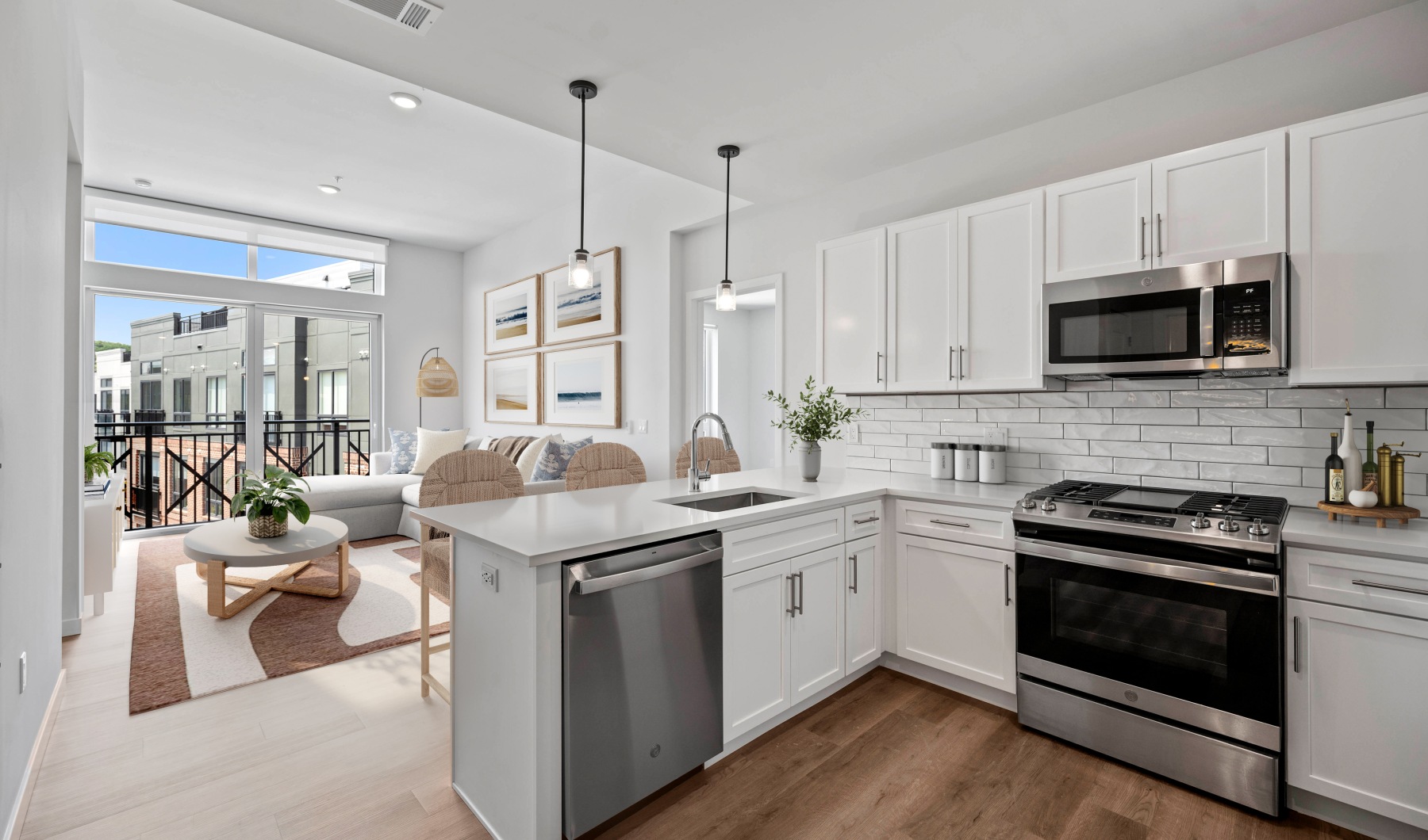 Luxury apartment kitchen with white cabinetry, white tile backsplash, kitchen island, stainless steel appliances, and wood like flooring