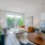 Living room with couch, chair, coffee table, Juliette balcony, and eat in dining table set for two